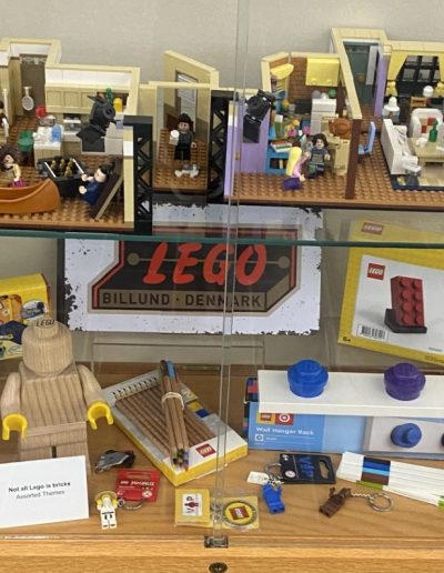Colorful Lego toys and assorted items neatly arranged in a display case, creating a fun and vibrant scene.