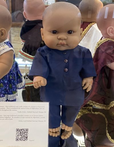 Display case showing a doll wearing traditional clothing