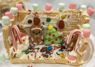 A delightful gingerbread house featuring an array of candies and marshmallows, creating a whimsical holiday scene.