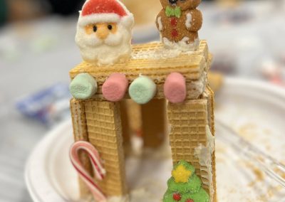 A whimsical gingerbread house designed to resemble a waffle house, adorned with colorful icing and candy decorations.