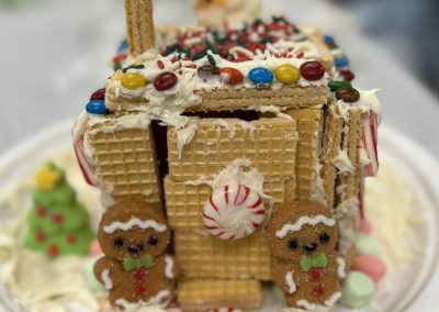 A beautifully decorated gingerbread house adorned with colorful candy and fluffy marshmallows, showcasing festive charm.